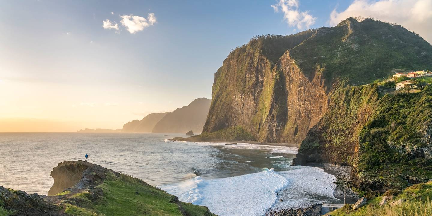 Homme surplombant le littoral et ses falaises au coucher du soleil - Île de Faial - Açores - Portugal