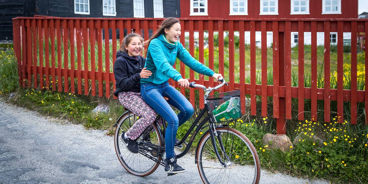 Deux jeunes filles sur un vélo dans les rues de Nanortalik - Groenland