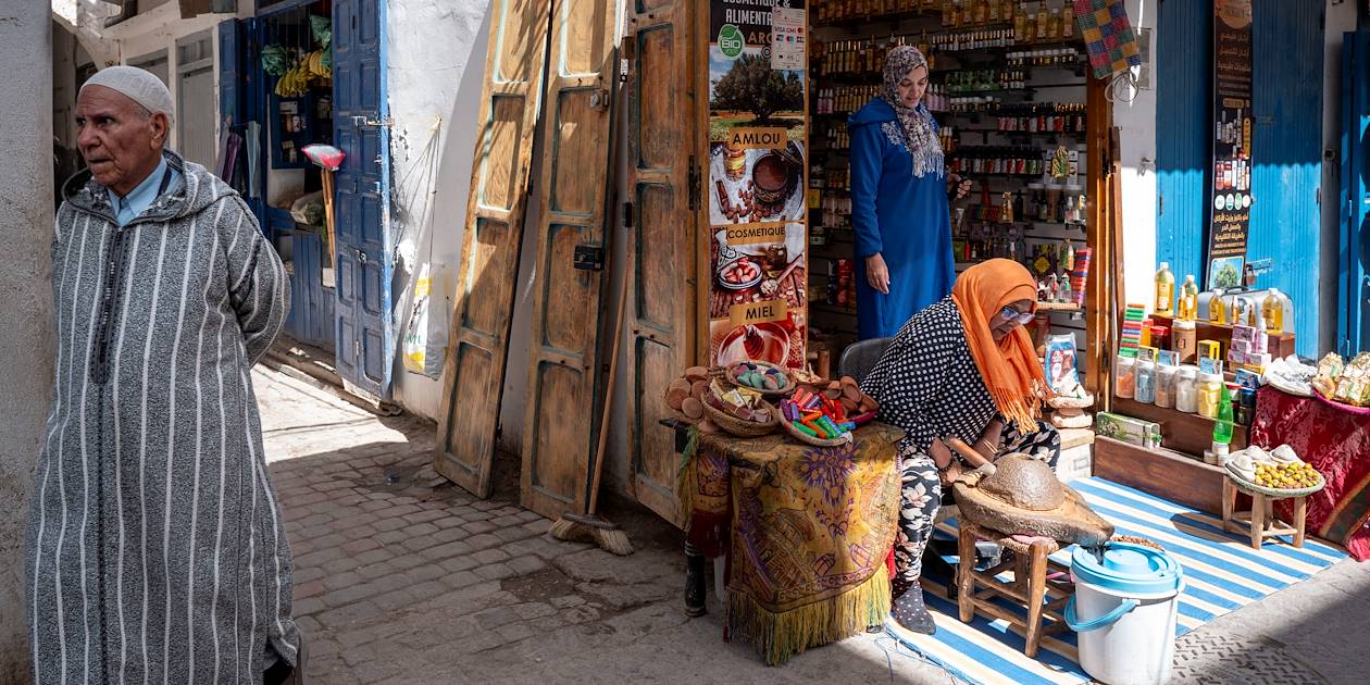 Femme fabriquant de l'huile d'argan devant sa boutique - Essaouira - Maroc