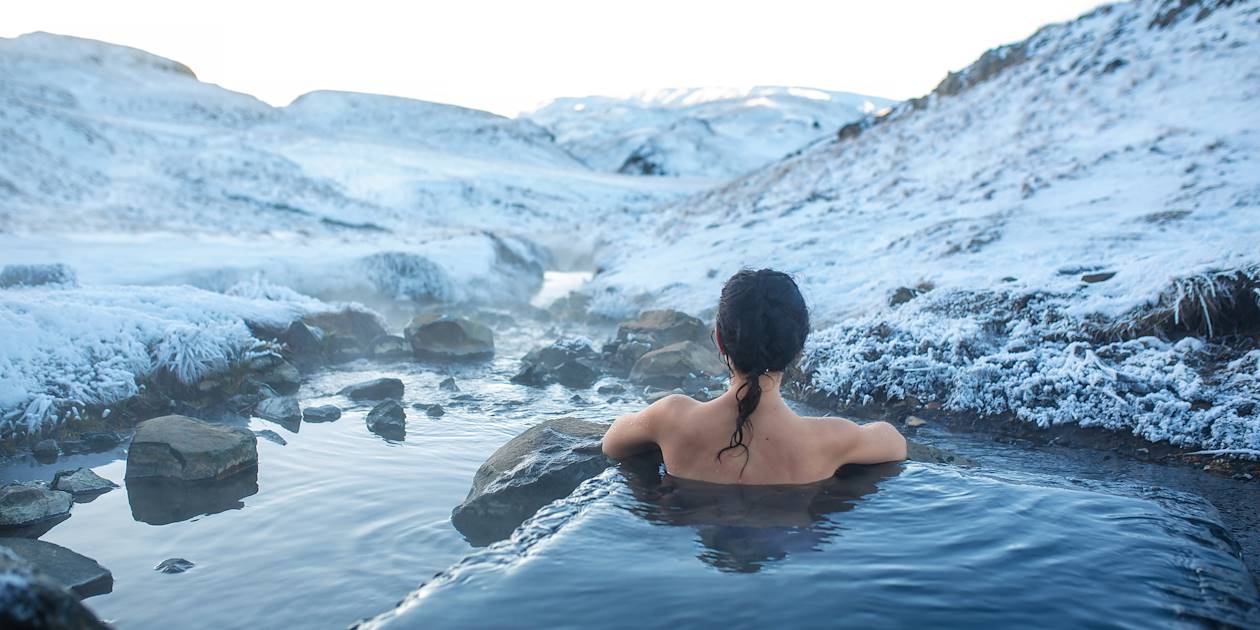 Bain thermal face aux montagnes enneigées - Islande