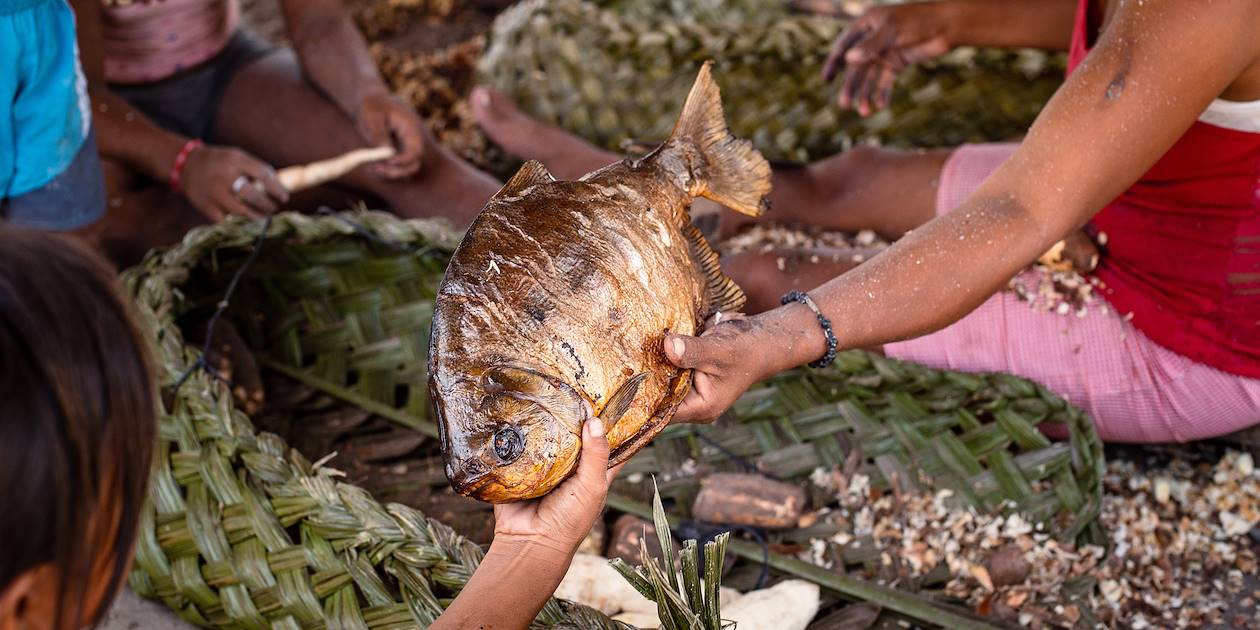Dégustation d'un poisson grillé avec une famille d'indigènes en Amazonie - Guyane