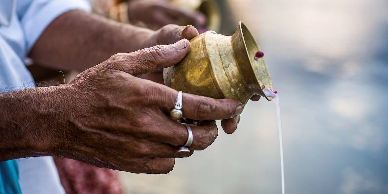Mains versant de l'eau sacrée dans le Gange pendant le culte quotidien - Inde