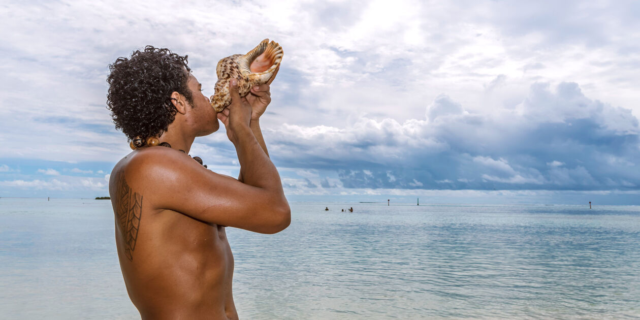 Polynésien soufflant dans une conque - Moorea - Polynésie