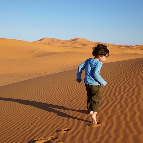 Enfant courant dans les dunes de Merzouga - Maroc