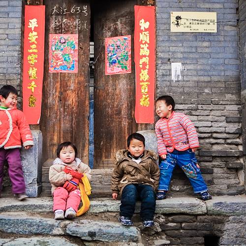 Enfants jouant devant une maison traditionnelle d'un hutong - Pékin - Chine