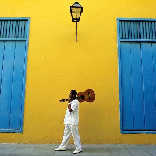 Portrait de musicien portant une guitare sur fond de façade coloniale - La Havane - Cuba