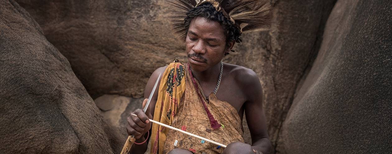 Homme Hadzabe préparant de nouvelles flèches pour la chasse - Tanzanie