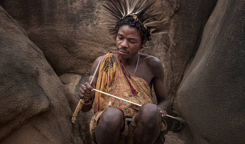 Homme Hadzabe préparant de nouvelles flèches pour la chasse - Tanzanie