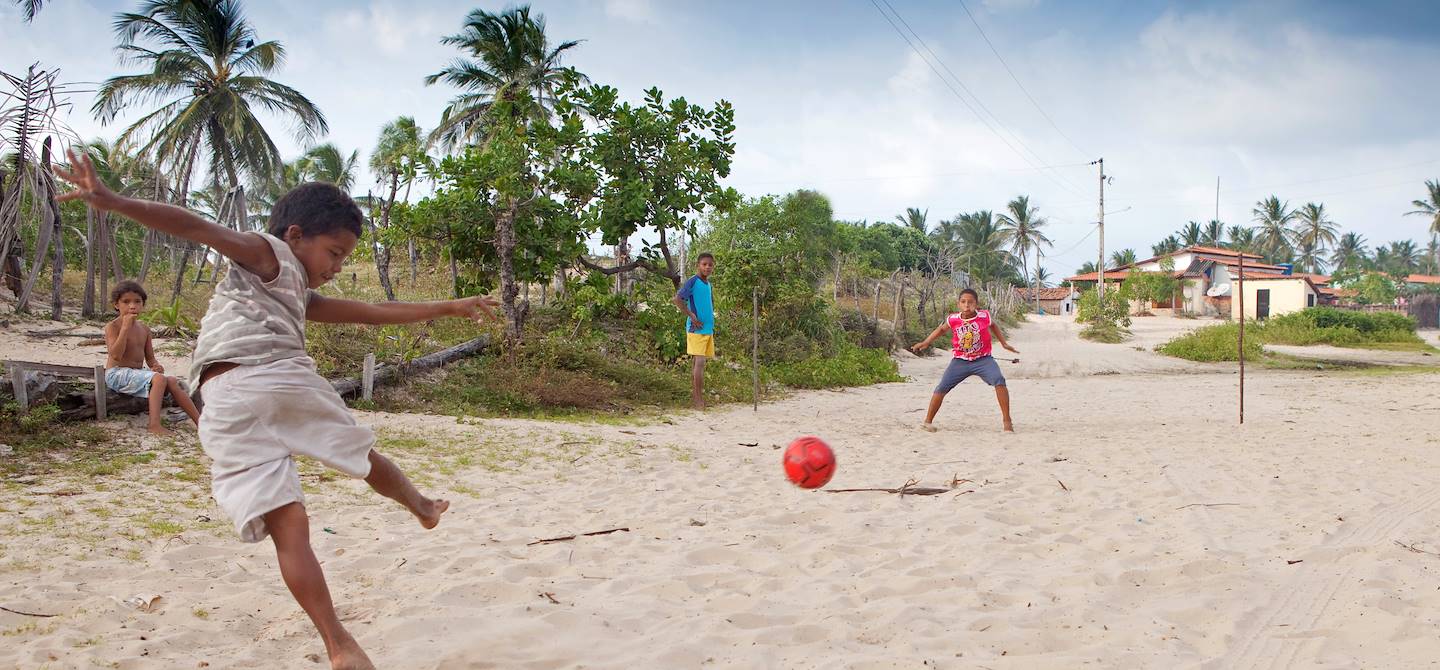 Enfant jouant au football dans le Parc National des Lencois Maranhenses - Atins - Brésil