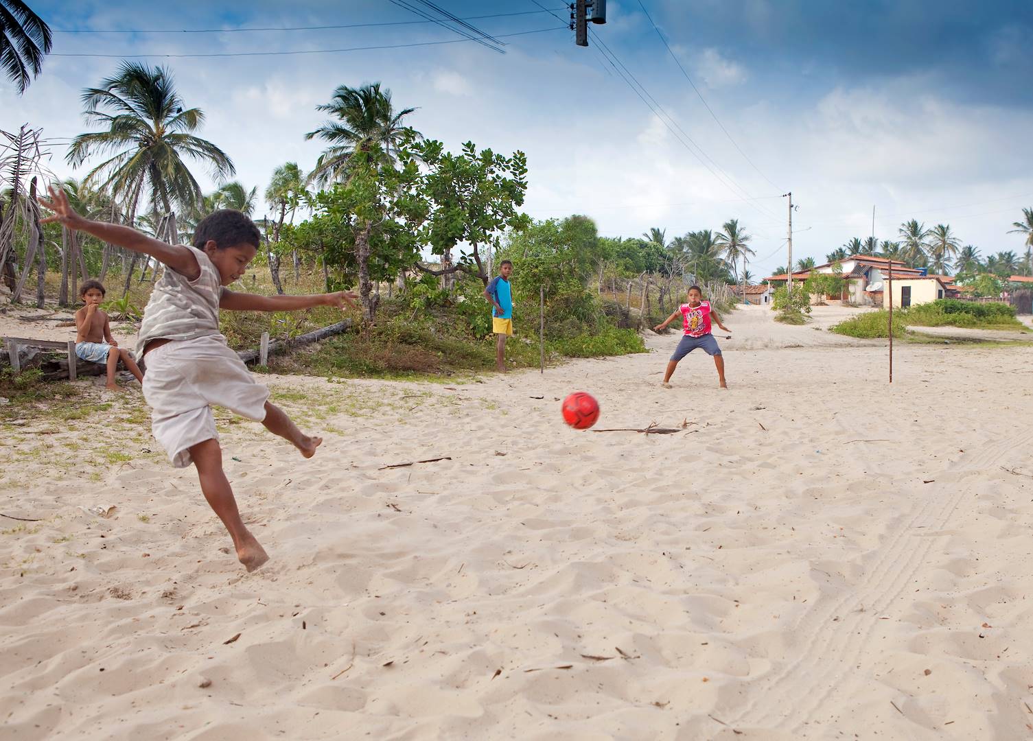 Enfant jouant au football dans le Parc National des Lencois Maranhenses - Atins - Brésil