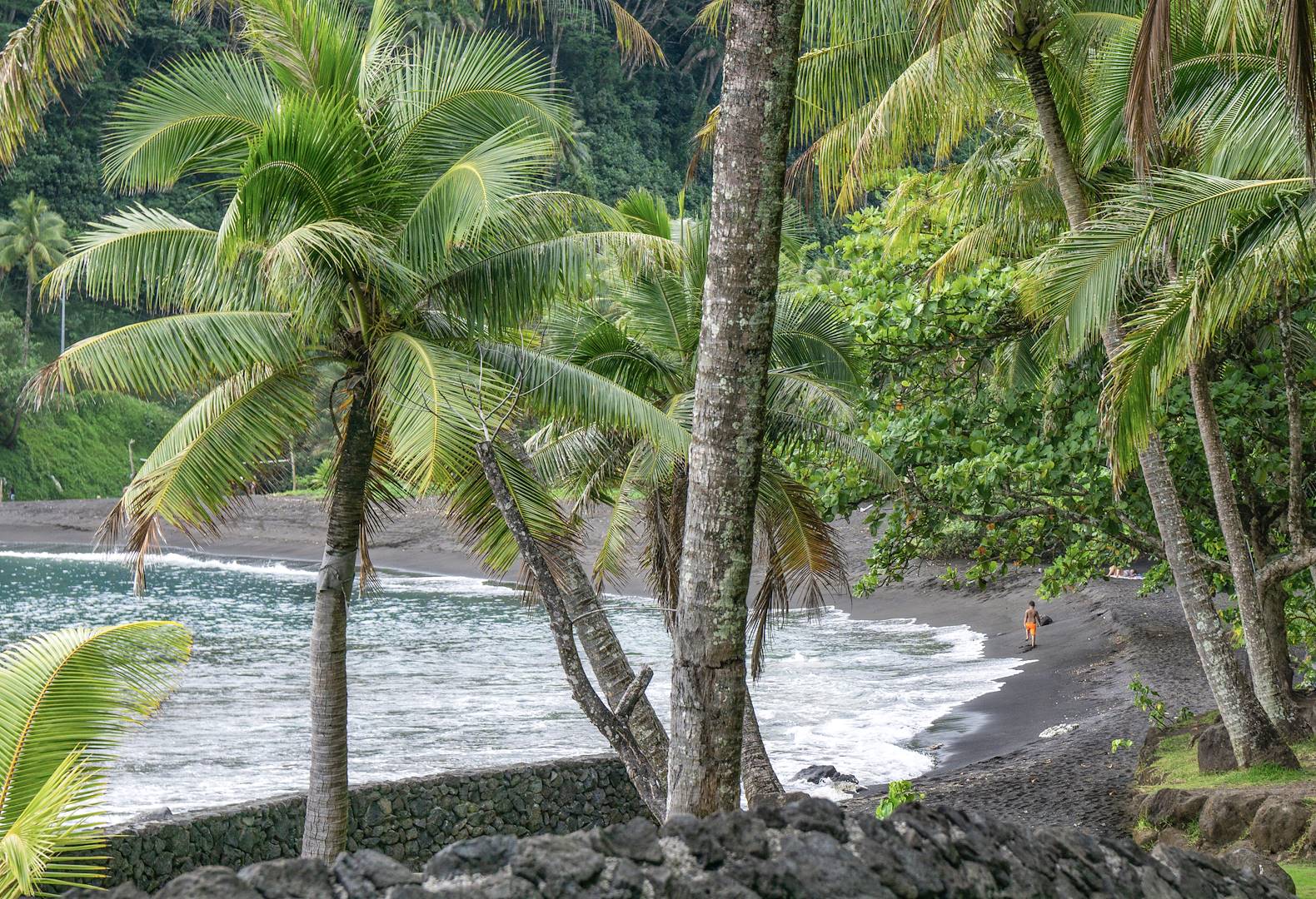 Scène de vie sur une plage de sable noir à Tahiti - Polynésie Française