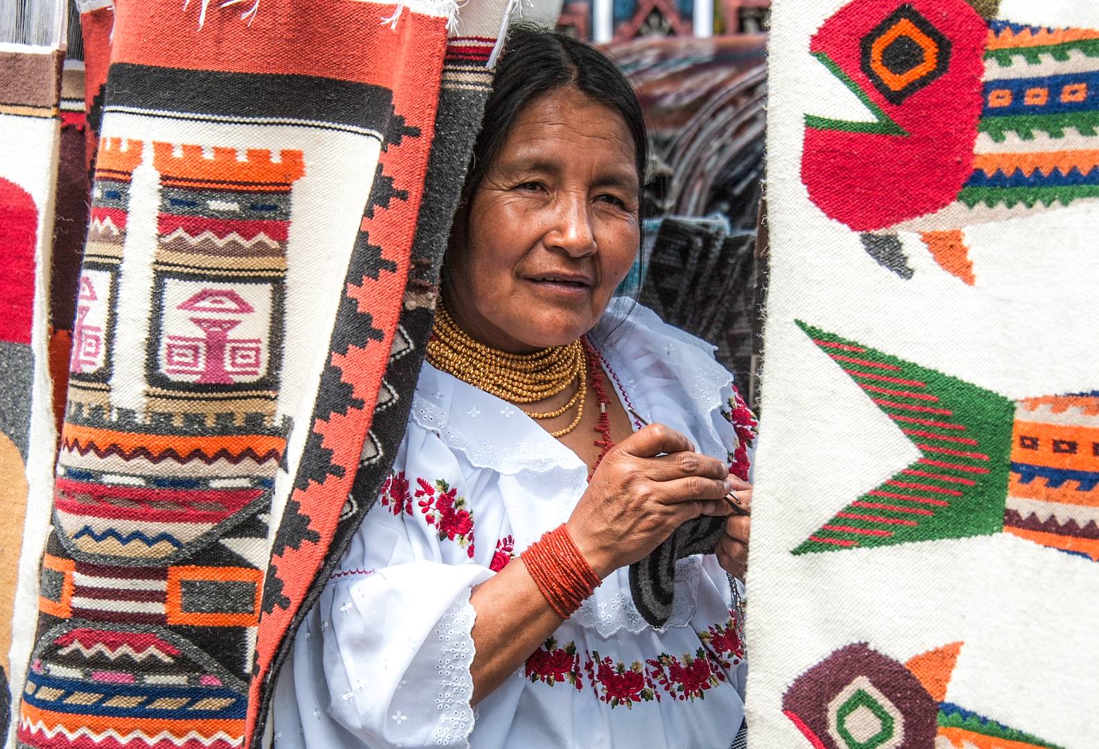 Femme vendant des tapis traditionnels sur un marché de Quito - Equateur