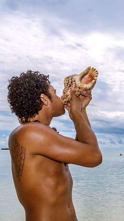 Polynésien soufflant dans une conque - Moorea - Polynésie