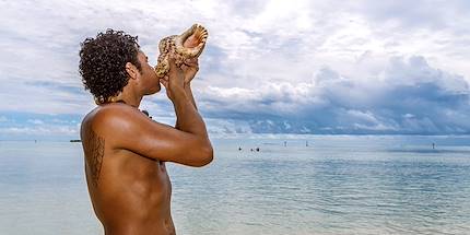 Polynésien soufflant dans une conque - Moorea - Polynésie
