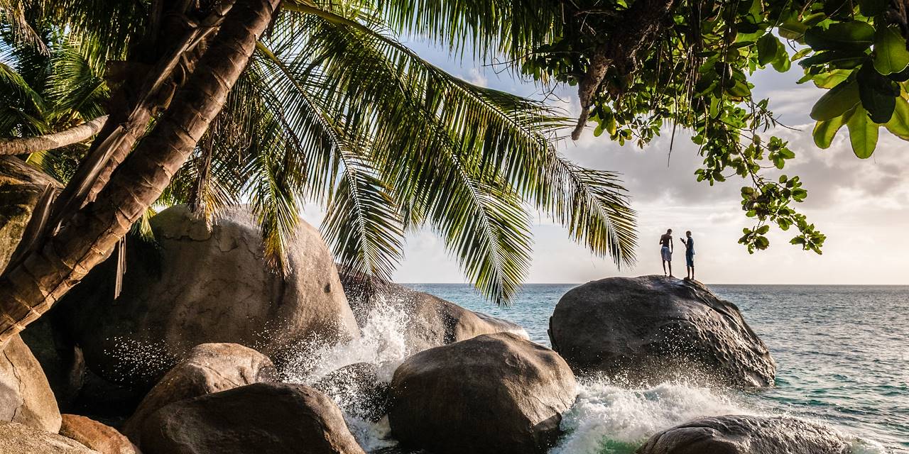 Jeunes hommes sur un rocher - La Digue - Seychelles