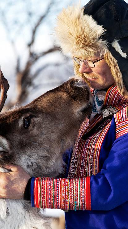 Homme en habit traditionnel sami et son renne - Laponie - Finlande