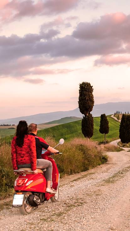 Couple en vespa au coucher du soleil - Val d'Orcia - Toscane - Italie