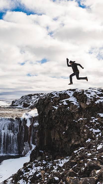 Homme sautant près d'une cascade - Islande